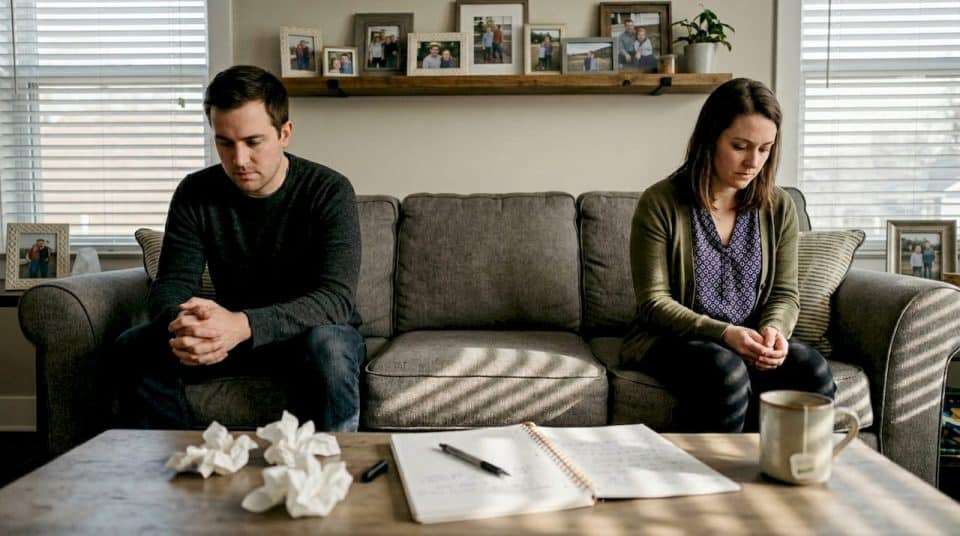 Couple quietly sitting in lived-in living room