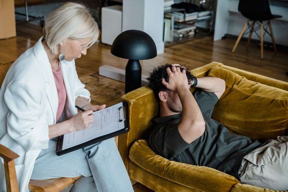 how to talk to your child about their mental health - A therapist conducts a session with a client discussing mental health in a cozy office setting.
