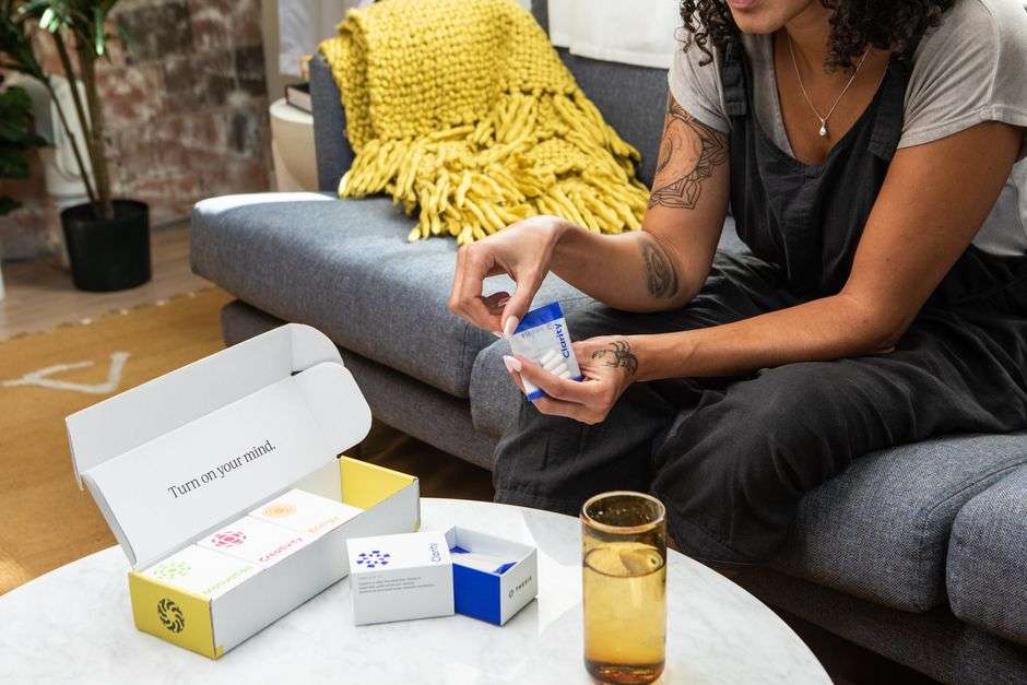 how to talk to your child about their mental health - A woman sitting on a sofa examining nootropic supplements, promoting wellness and clarity.
