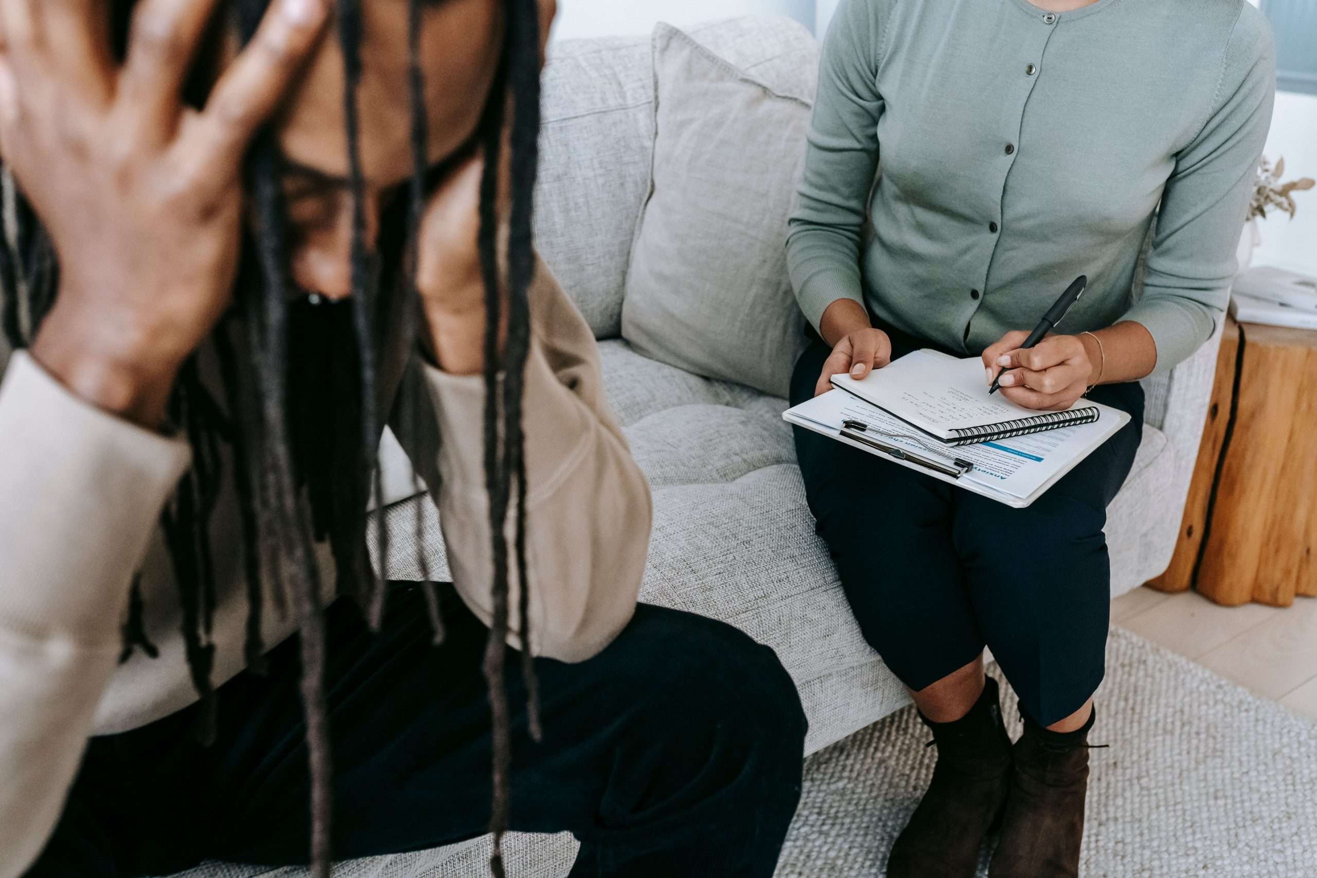 kelowna marriage counselling - A therapy session showing a concerned patient and a therapist taking notes.