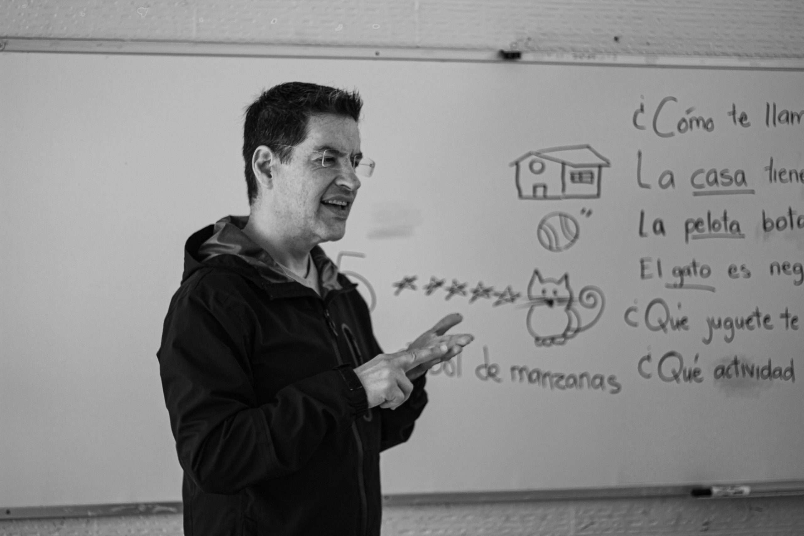 love language examples - A Spanish teacher explaining language concepts on a whiteboard in class.
