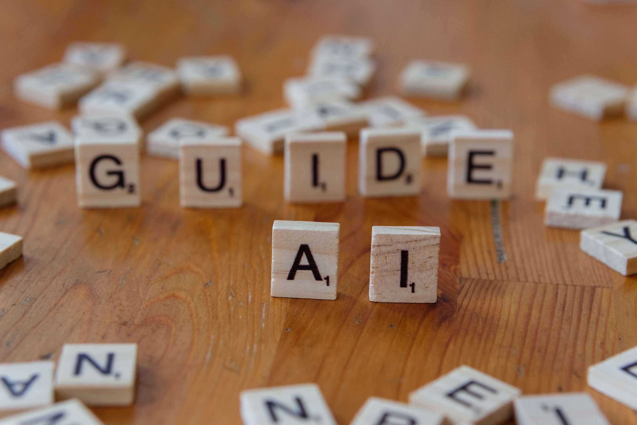 love language examples - Scrabble letters spelling 'GUIDE' and 'AI' on a wooden surface, suggesting direction and technology.