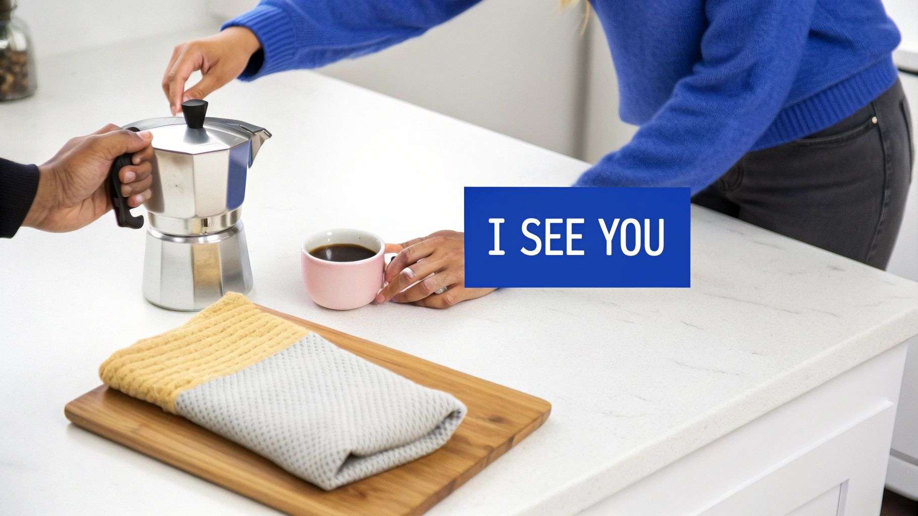 Two people prepare coffee on a kitchen counter, one holding a moka pot, the other a pink cup.