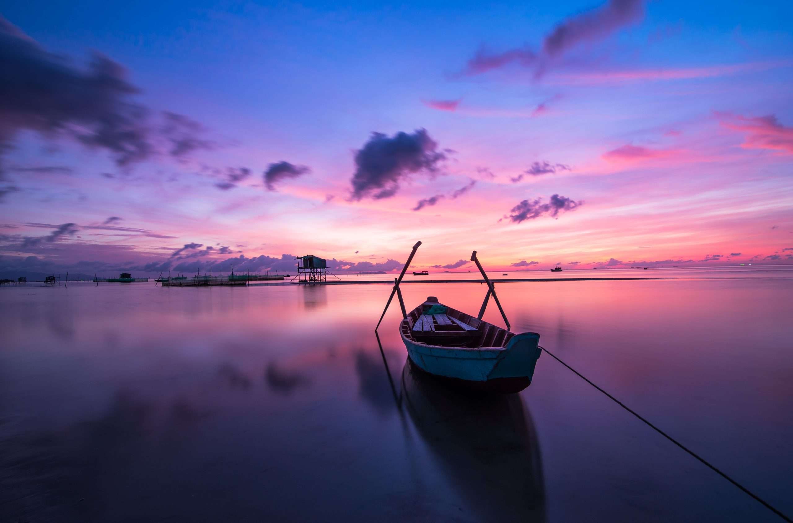 what are the 7 love languages - A tranquil tropical sunrise with a lone boat on calm waters.